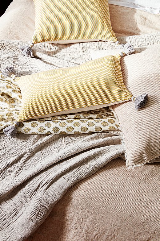 Tasseled corners and fringed edges add refinement to the organic materials. Shown above: Logan Duvet Cover and Sham in Terracotta, Harbour Matelassé Blanket in Taupe, Ella Square and Lumbar Pillows in Citrus.
